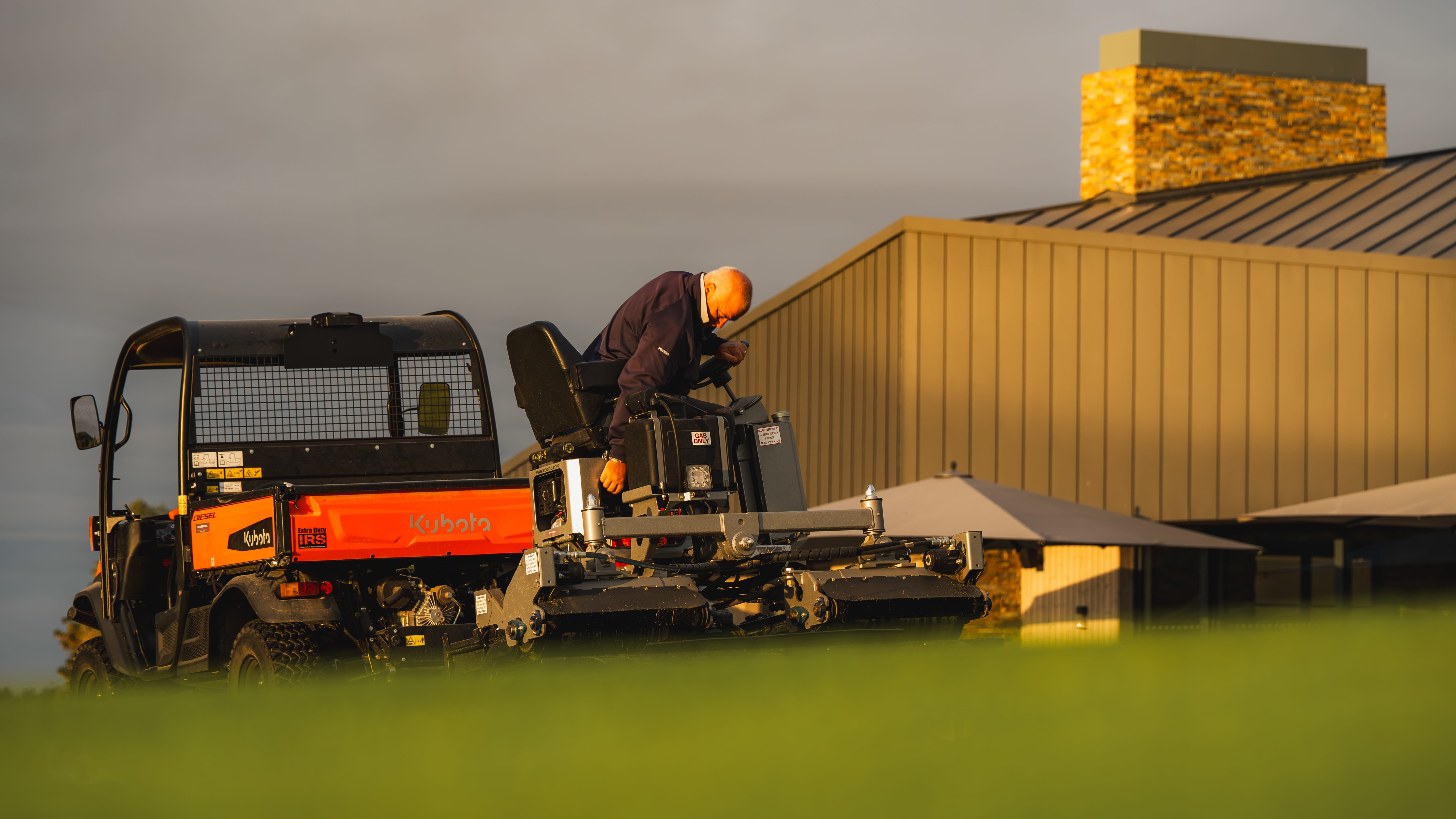 Greenkeepers loading a utility vehicle at the start of the shift