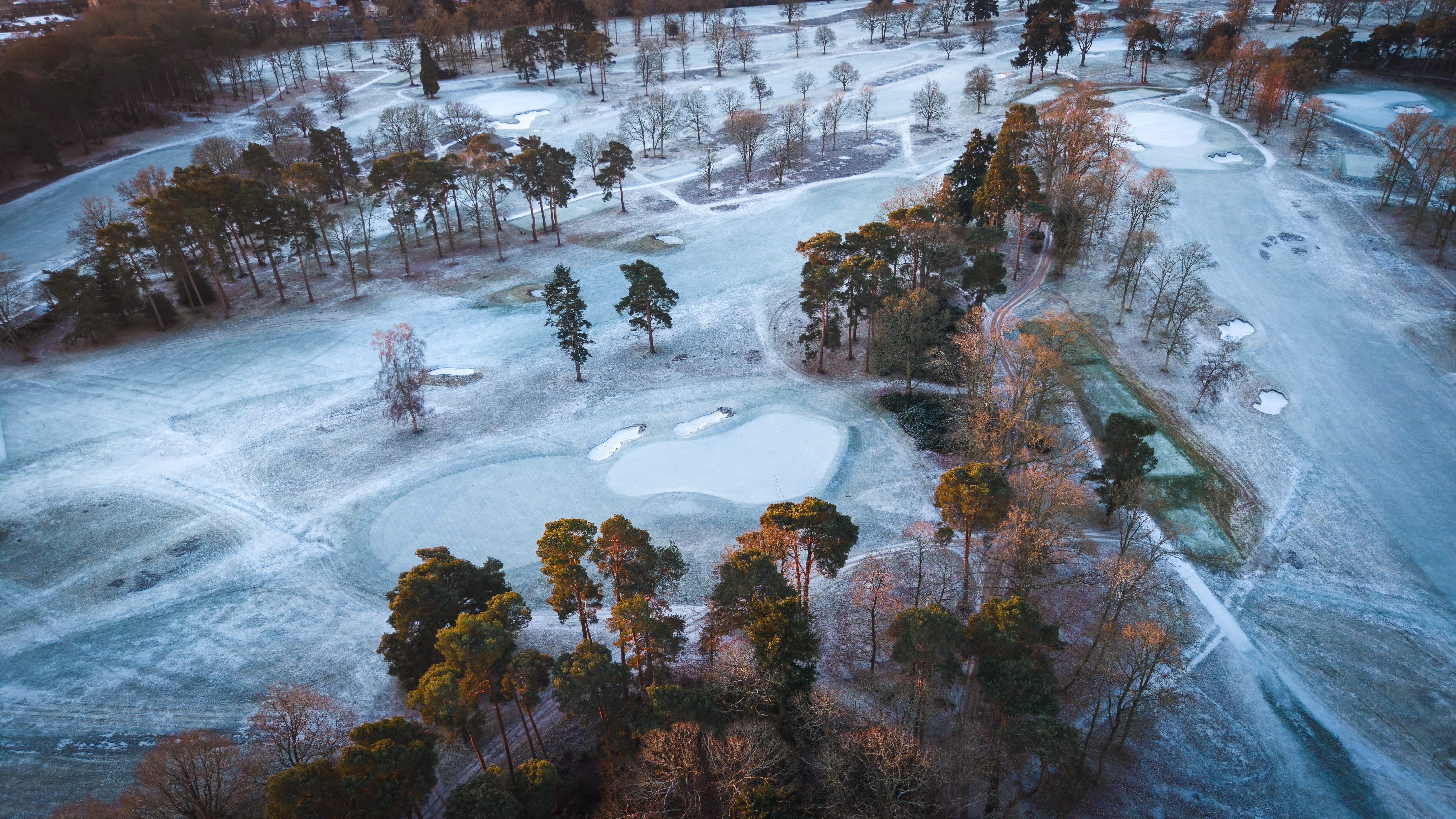 A hard frost across the whole course at first light, bare trees and white bunkers from the air
