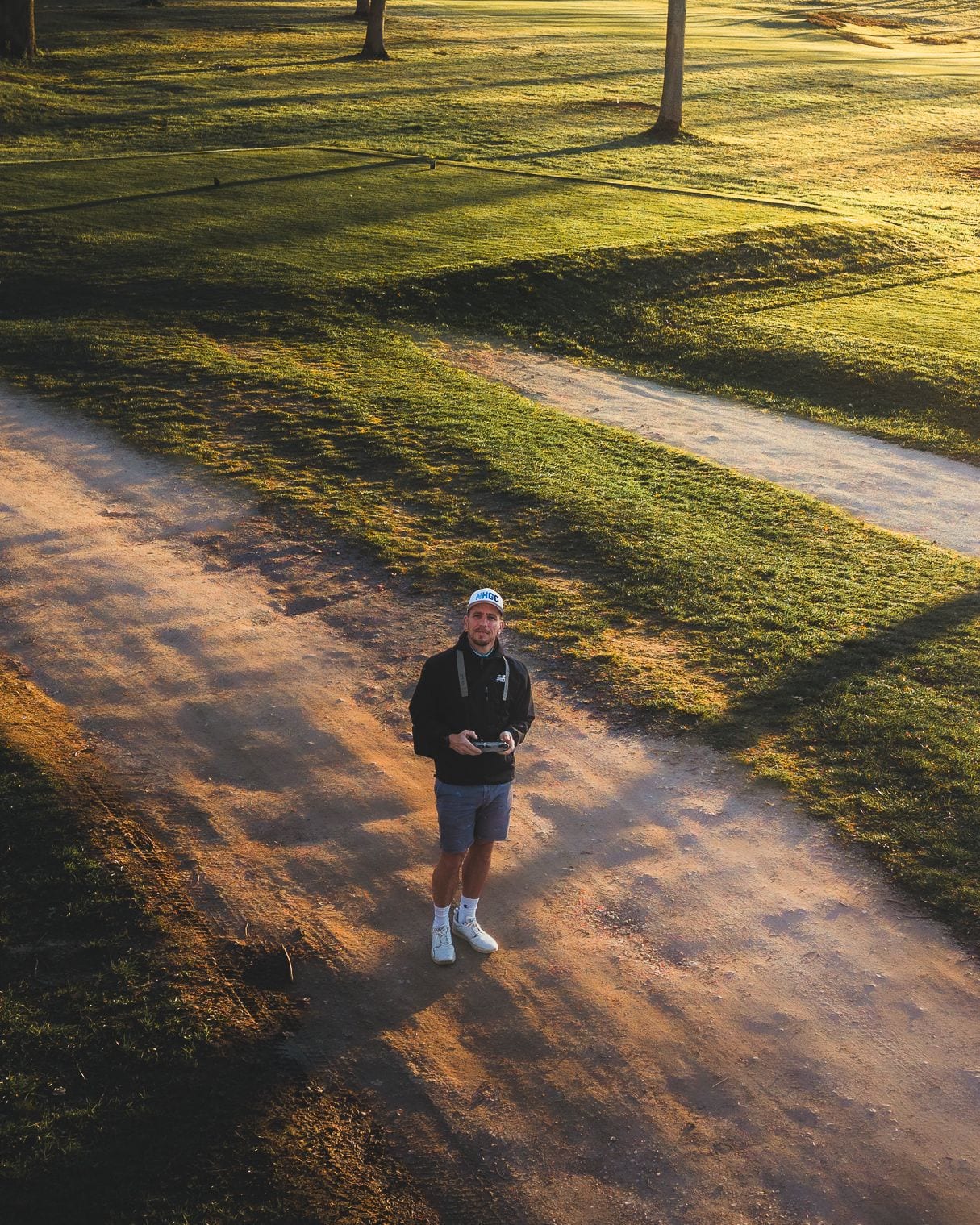 Ollie Rastall flying a drone on a golf course at sunrise
