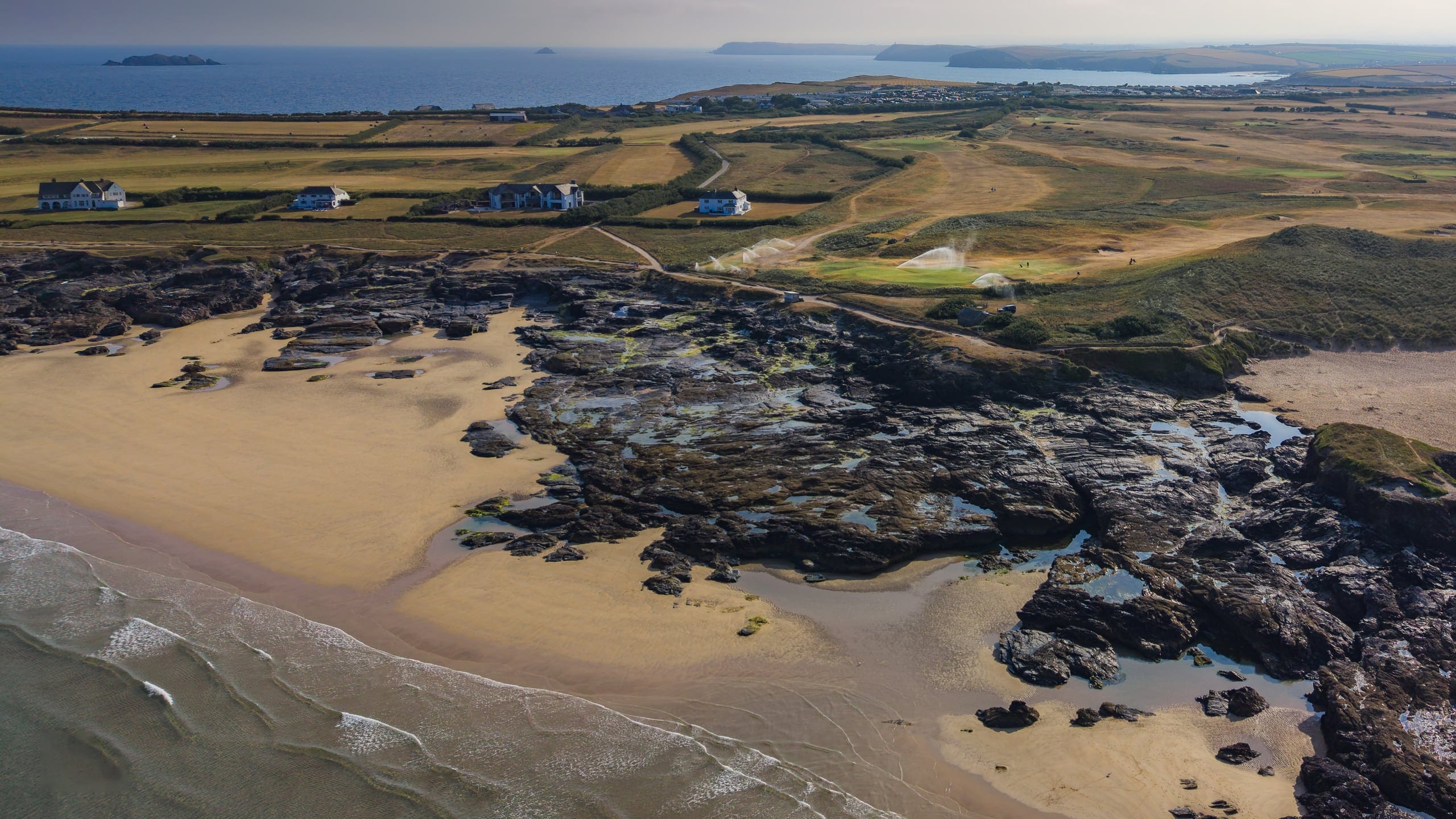 Rocks and beach at low tide beneath the links