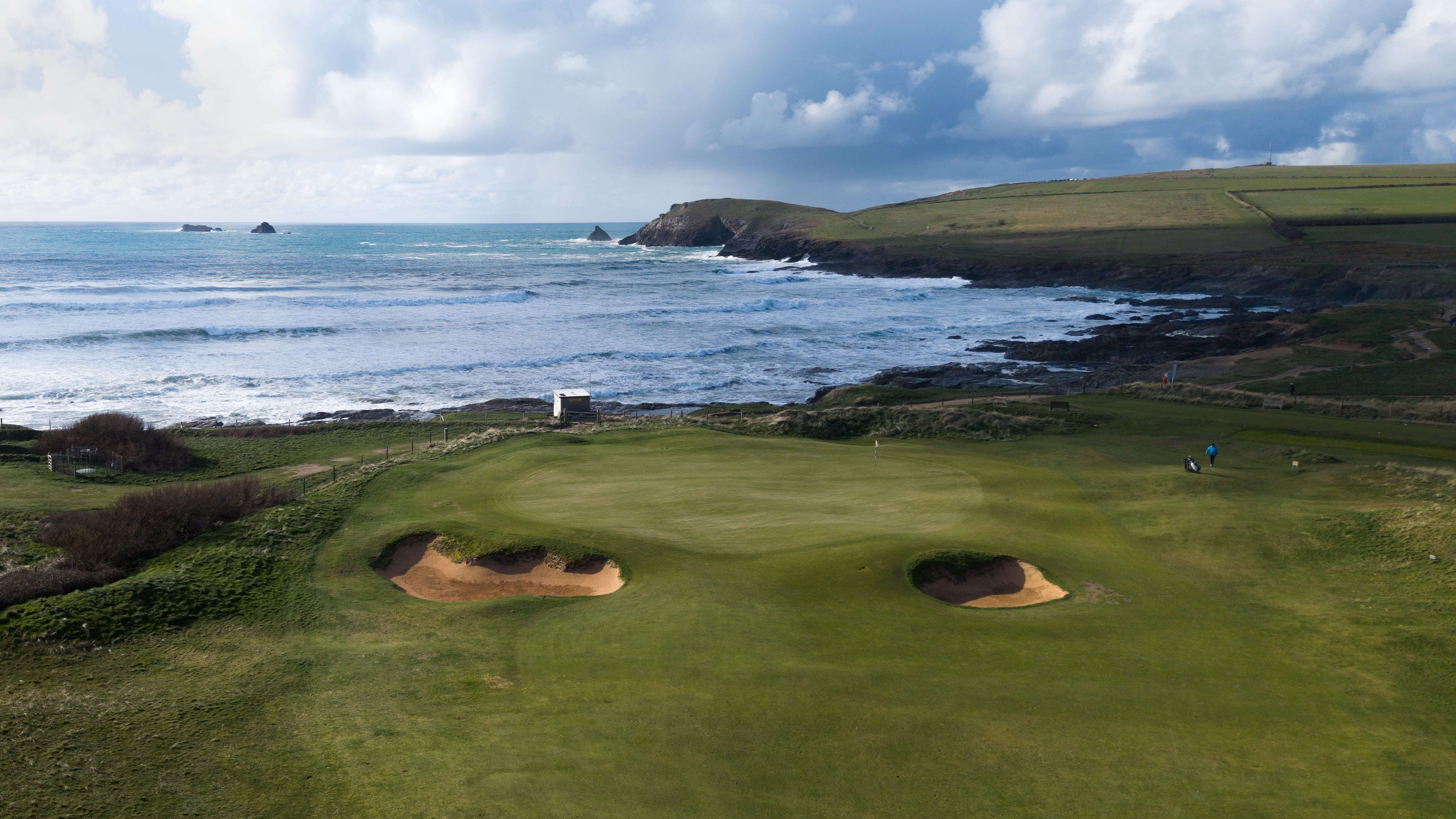 A green at Trevose above the Atlantic in early spring, surf breaking along the headland behind it