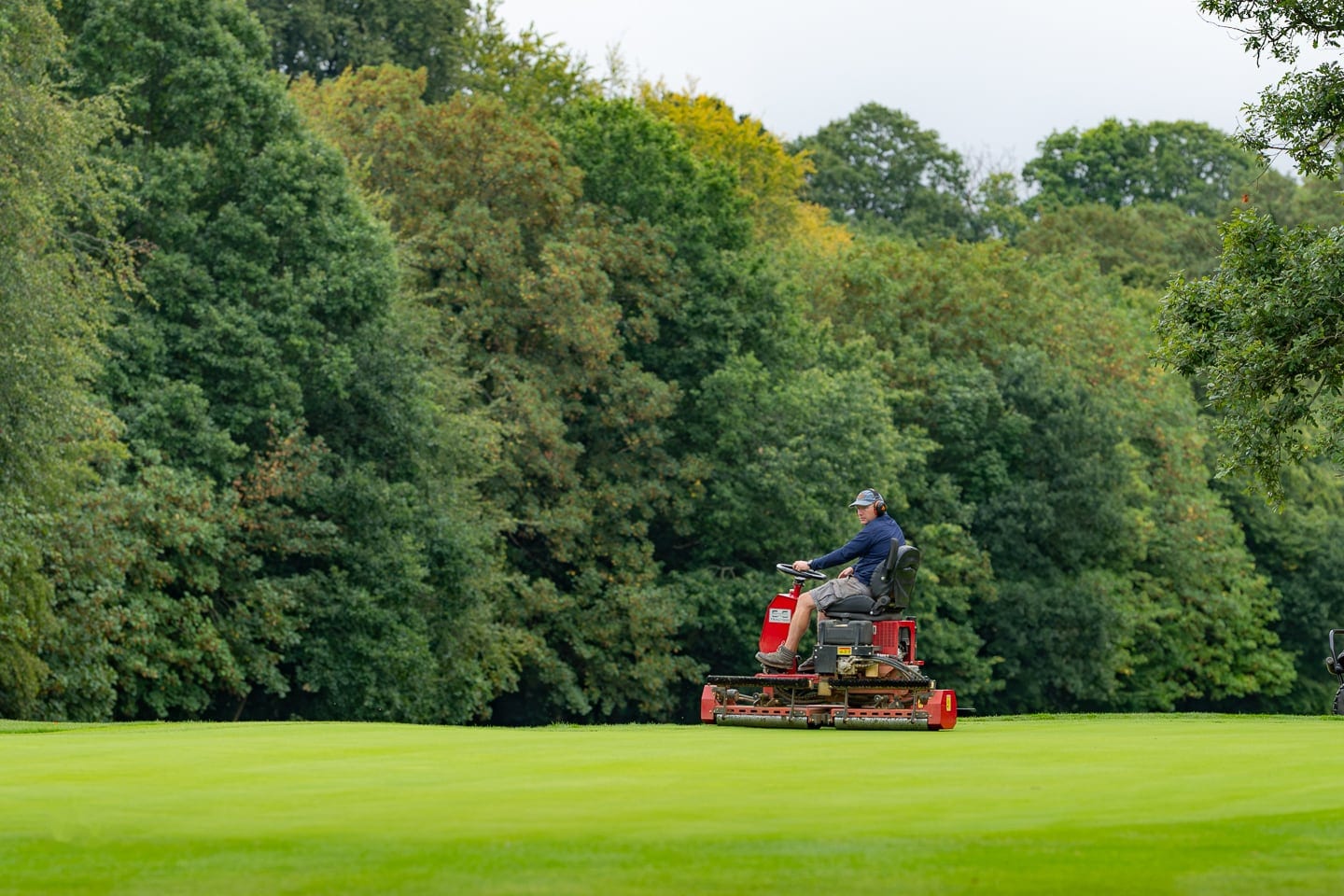 A mower cutting a green in the open
