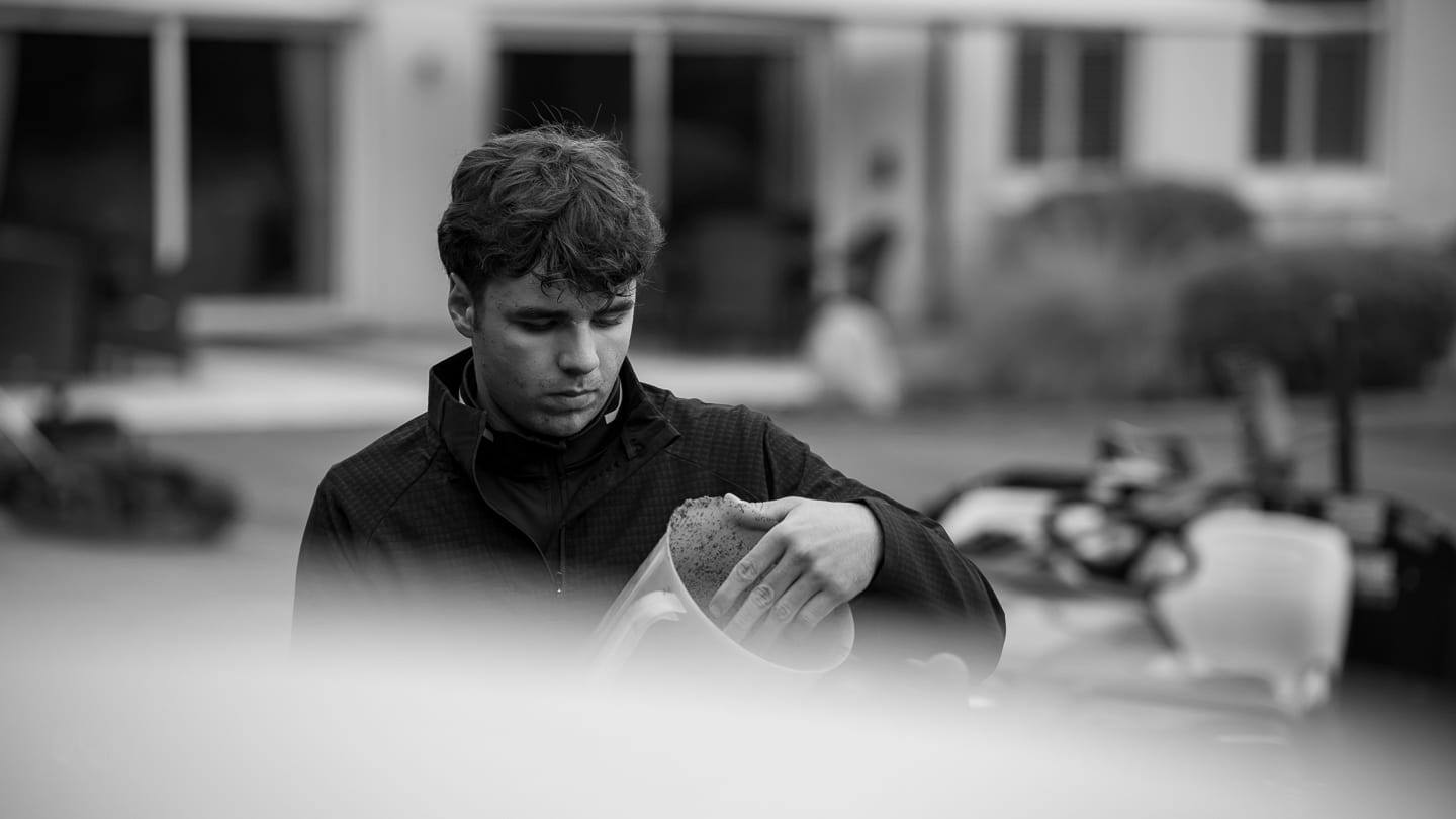 A greenkeeper filling a spreader with fertiliser, black and white